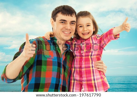 Joyful father with daughter showing thumbs up. Fathers day, family holiday, happiness concept