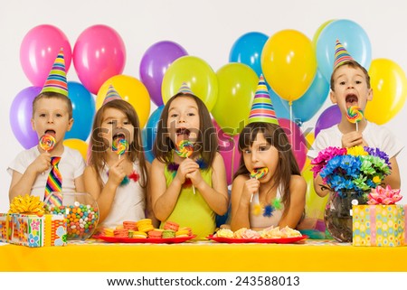 Group of joyful little kids having fun at birthday party. Holidays concept.