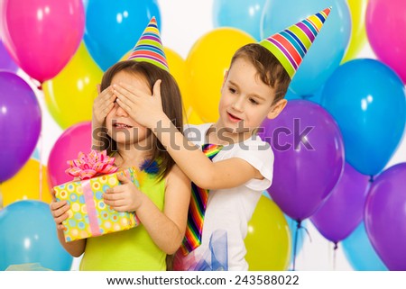 Joyful little kid girl receiving gifts at birthday party. Holidays concept.