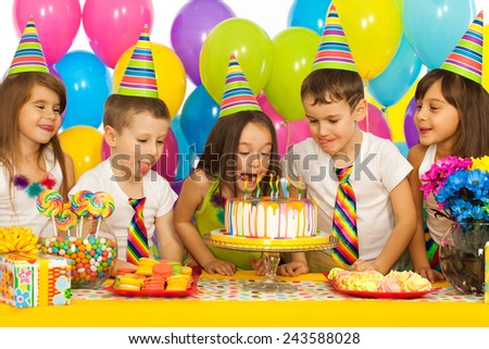 Group of joyful little kids with cake at birthday party. Holidays concept.