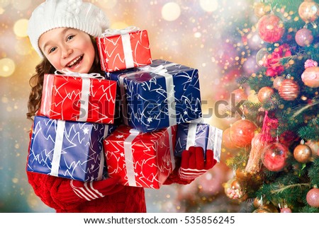 Merry Christmas and Happy New Year Holidays! Happy little girl with many gifts near Christmas tree. Christmas sale