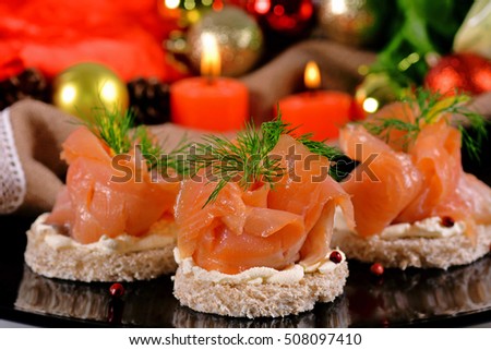 Holiday appetizer with salmon canapes on a background of Christmas decorations