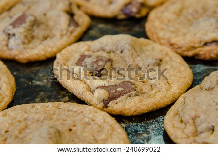 A close up of a chocolate chunk cookie cooling on a granite countertop