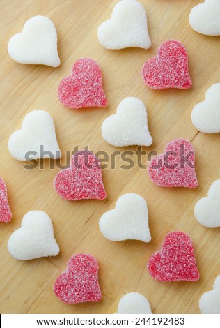 Red and white gummy hearts diagonally across a butcher block