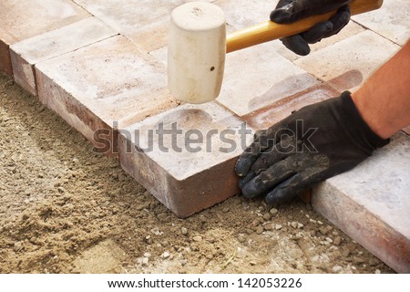 Installing Paver Bricks On Patio, Mallet To Level The Stones