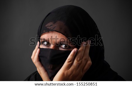 Middle-aged muslim woman hiding her face looking angry