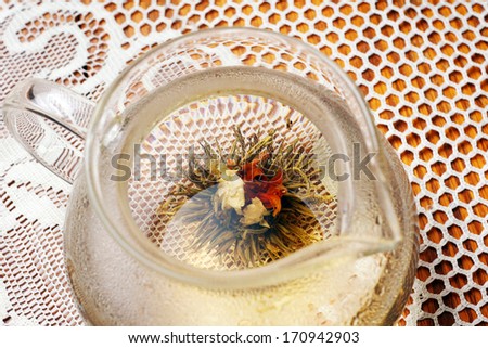 Blossom tea opening in tea pot with boiling water