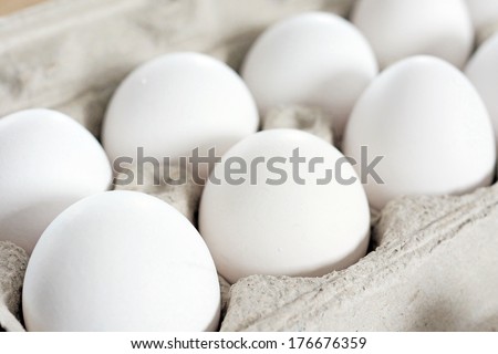 White eggs in recycled cardboard container or crate, food staple.