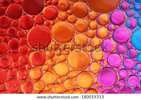 Oil drop and water over red, orange, pink and blue background-fun abstract