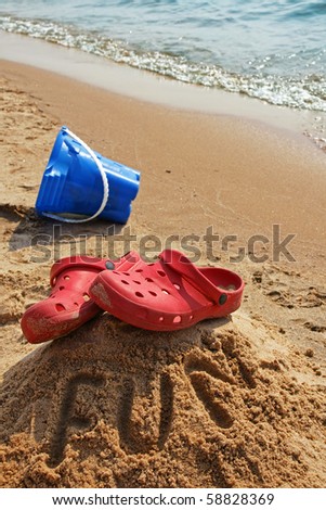Vertical of red shoes close to the shoreline, placed on top of a hill with the word \