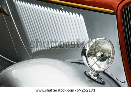Detail of old silver collectible car,cool light reflections.