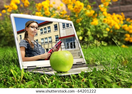 Back to school: Picture on laptop screen of confident young female student holding books and standing in front of school building entrance.