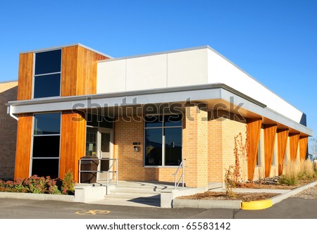 Small modern public office building mixing wood and brick material.