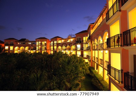 Gorgeous tropical five stars resort at sunset with all the rooms with balconies lit up.