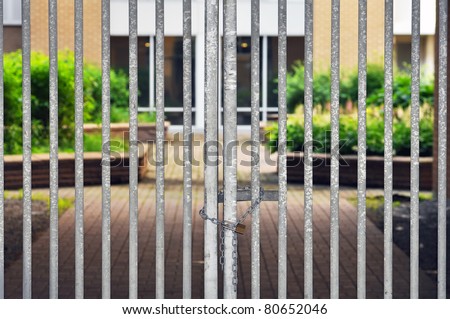 Gated residential community, locked fence with padlock and chain restricting access to luxury condos.