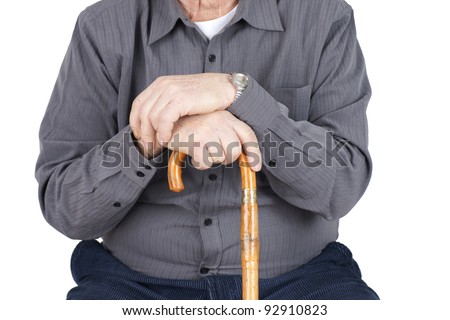 Great detail shot of senior man or elderly seated and leaning on his cane, focus on hands.