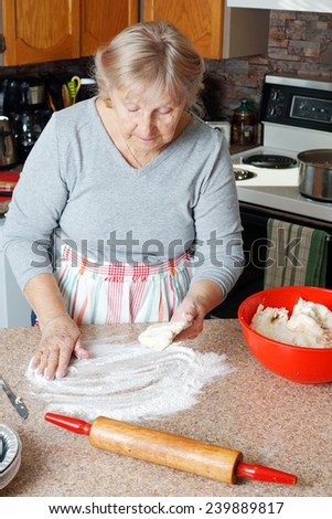 Senior woman or grandma making pie in her home kitchen