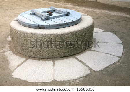 Ancient Asian stone deep well with hardwood cap closed