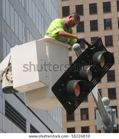 Houston, Texas - September 18, 2008: Public Safety Worker Fixing Tilted Red Traffic Light after Hurricane Ike (Editorial)