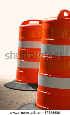 Two Orange Traffic Barrels on Concrete