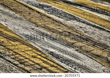 Cracked Yellow and White Paint on Black Asphalt Road