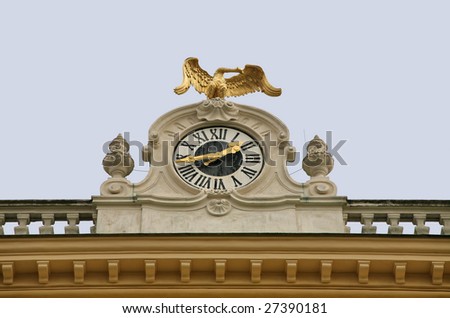 Classical Stone Clock with Golden Austrian Eagle atop Schonbrunn Castle against blue sky