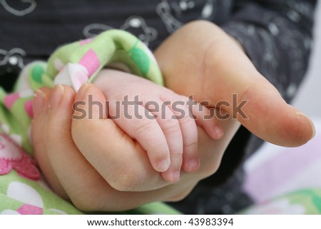 Motherly Hand Clasping Baby Hand in Love