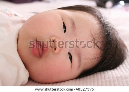 stock photo Cute Asian Baby girl looking forward with curious eyes