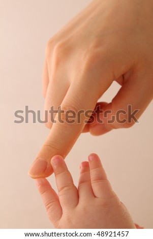 Beautiful hand of mother touching cute hand of baby infant