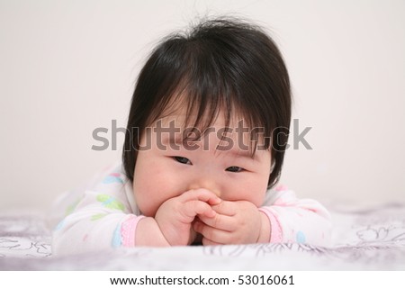 Ultra Cute Asian Baby Infant with Hands Clasped in Front of Mouth