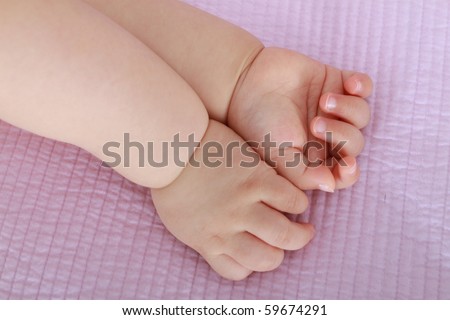 Beautiful Nine Month Old Asian Baby Infant Girl hands together on pink bed sheet
