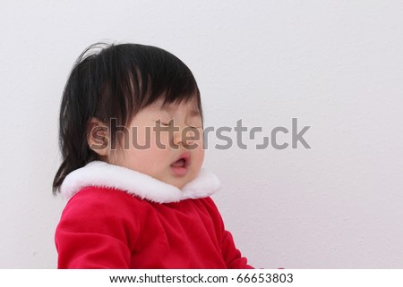 Beautiful One Year Baby Asian Toddler in Red and While Santa Suit Getting Ready to Sneeze while Celebrating Christmas Holiday with Good Cheer