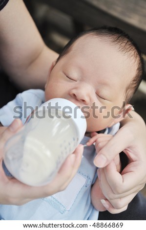 mom feeding little chinese baby boy
