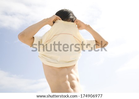 Japanese Man taking off T-shirt