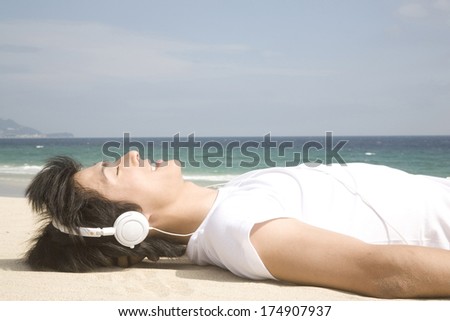Japanese Man listening to music at the beach