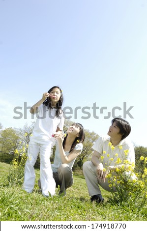 Japanese Family blowing bubbles in park