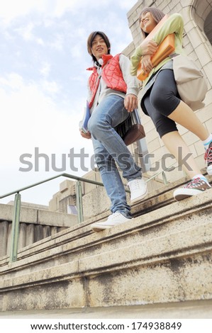 Japanese University students couple going down stairs of university