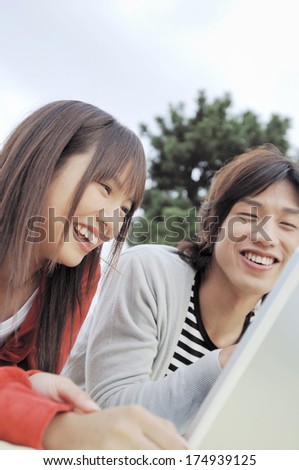 Japanese University student couple looking at laptop