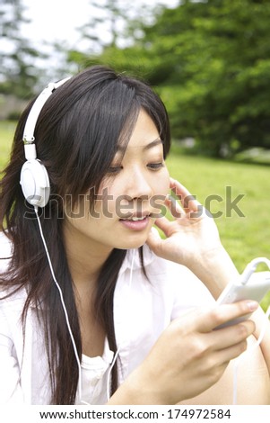 Japanese Woman listening to music in the park