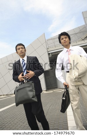 Japanese businessmen walking away from office building