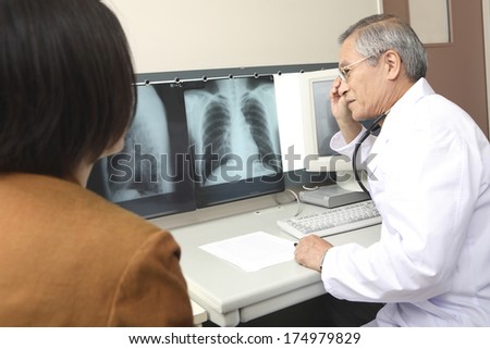 Japanese Doctor looking at xrays Japanese Doctor looking at xrays