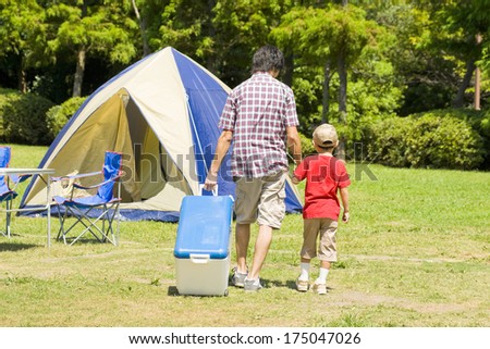Japanese Father and son walking and holding hands at the campsite