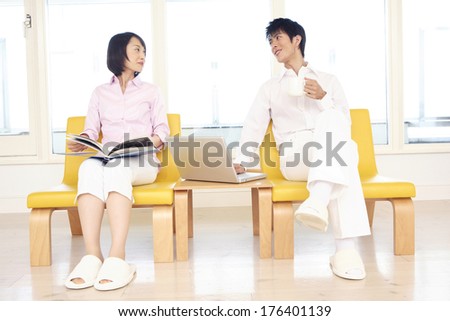 Japanese man and Japanese woman talking while sitting in a chair