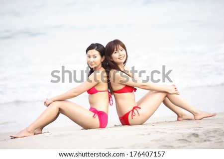 Japanese woman in swimsuit sitting back to back