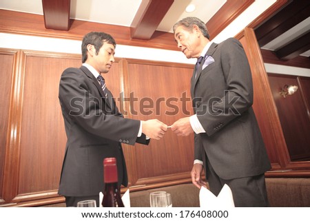 Japanese businessmen exchange business cards at the restaurant