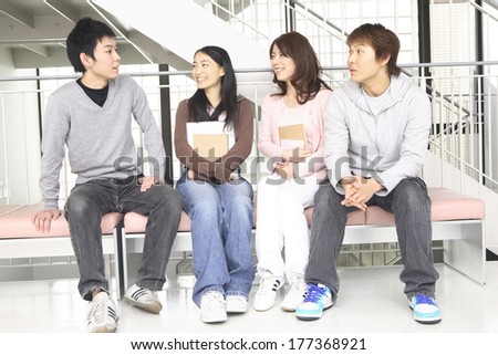 Japanese College students talking while sitting on a bench
