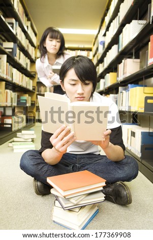 Japanese Students reading a book while sitting in library