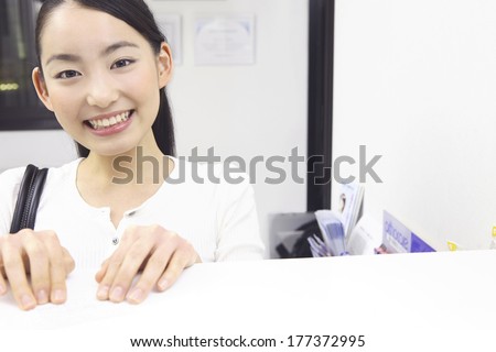 Japanese woman in front of the front desk of dental clinic