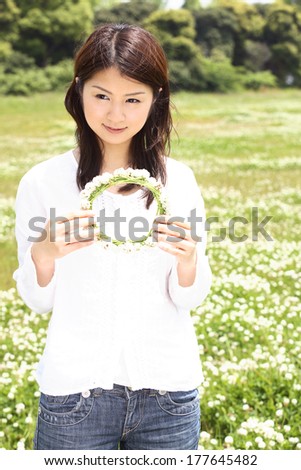 Japanese woman having a crown of the white nail on the grass