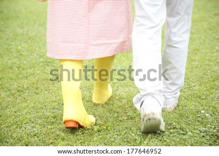 The feet of a Japanese couple walking on the park on a rainy day